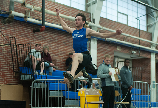 Photo by Todd Rundstrom Lindsey Larabee soars through the air during one of his long jump attempts Friday afternoon during the Loper Indoor Invite track meet at Cushing Coliseum.