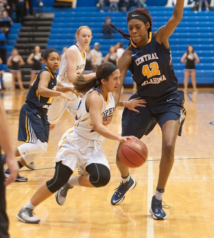 Photos by Todd Rundstrom Senior Alexa Hogberg drives by Central Oklahomas Jesheon Cooper at the Health and Sports Center on Thursday. Hogberg finished with seven points and three assists to upend the previous top-ranked MIAA Bronchos.