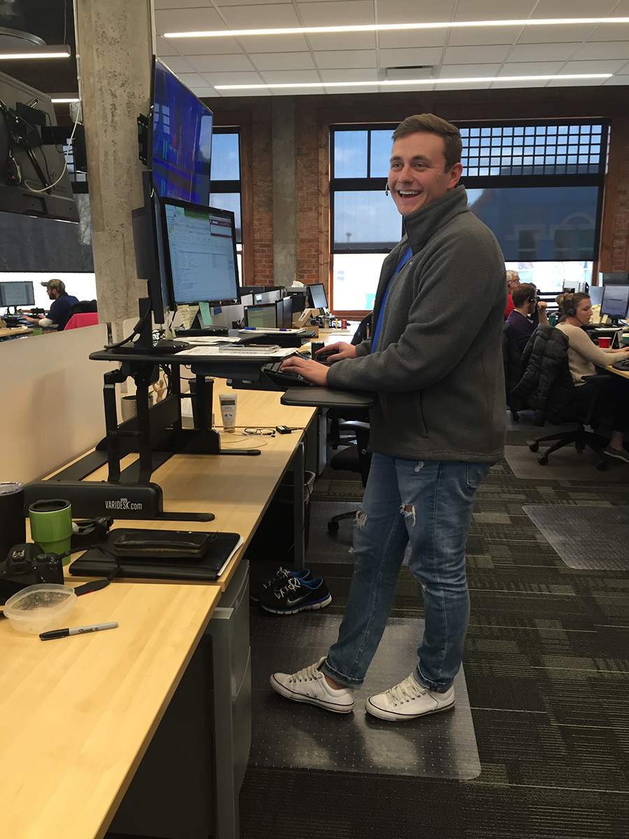Jeffrey Olson, a 2015 UNK graduate with a degree in business administration with an emphasis in marketing, at his stand up desk in the GIX office in Grand Island. “It’s a team atmosphere, where we’re always pushing towards the same goal – to make GIX the best freight brokerage in the country,” Olson said.