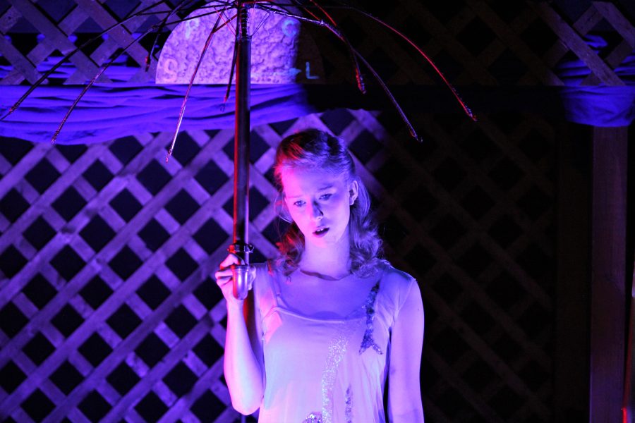 Eurydice stands under umbrella.