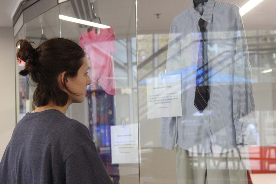 UNK student Claire Nash stops at the “What Were You Wearing?” exhibit designed to end the stigma placed upon the clothing of sexual assault victims.