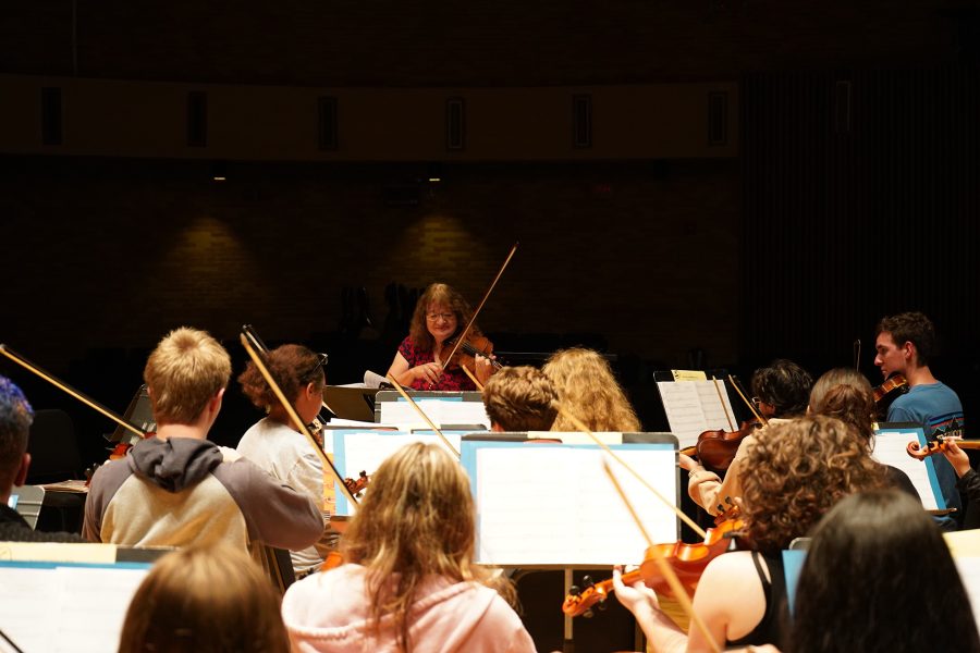 Former visiting instructor, Connie Moon, tunes her violin with her group of high school musicians during the Orchestra Festival. Photo provided by Kolton Maturey / Antelope Staff