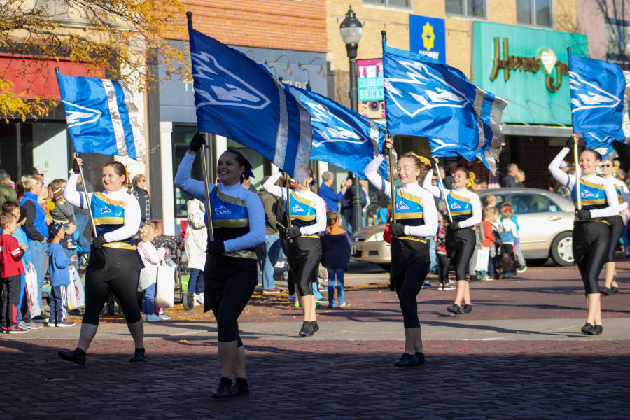 The color guard leads the Pride of the Plains Marching Band in Downtown Kearney at the largest Homecoming parade in Nebraska. Photo provided by Shelby Berglund / Antelope Staff