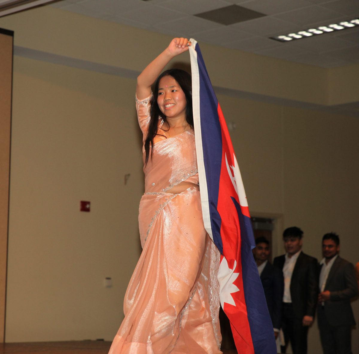 Sumina Limbu carries Nepals flag during the fashion show. Photo by Ricardo Hernandez / Antelope Staff