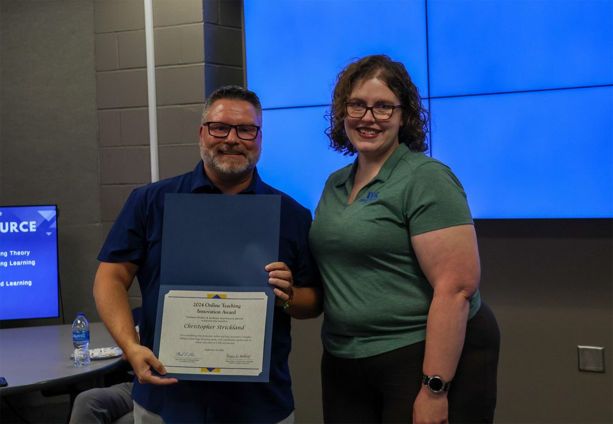 Christopher Strickland receives the 2024 Online Teaching Innovation Award presented by the former recipient, Amanda Sladek. Photo by Jenna Heinz / Antelope Staff