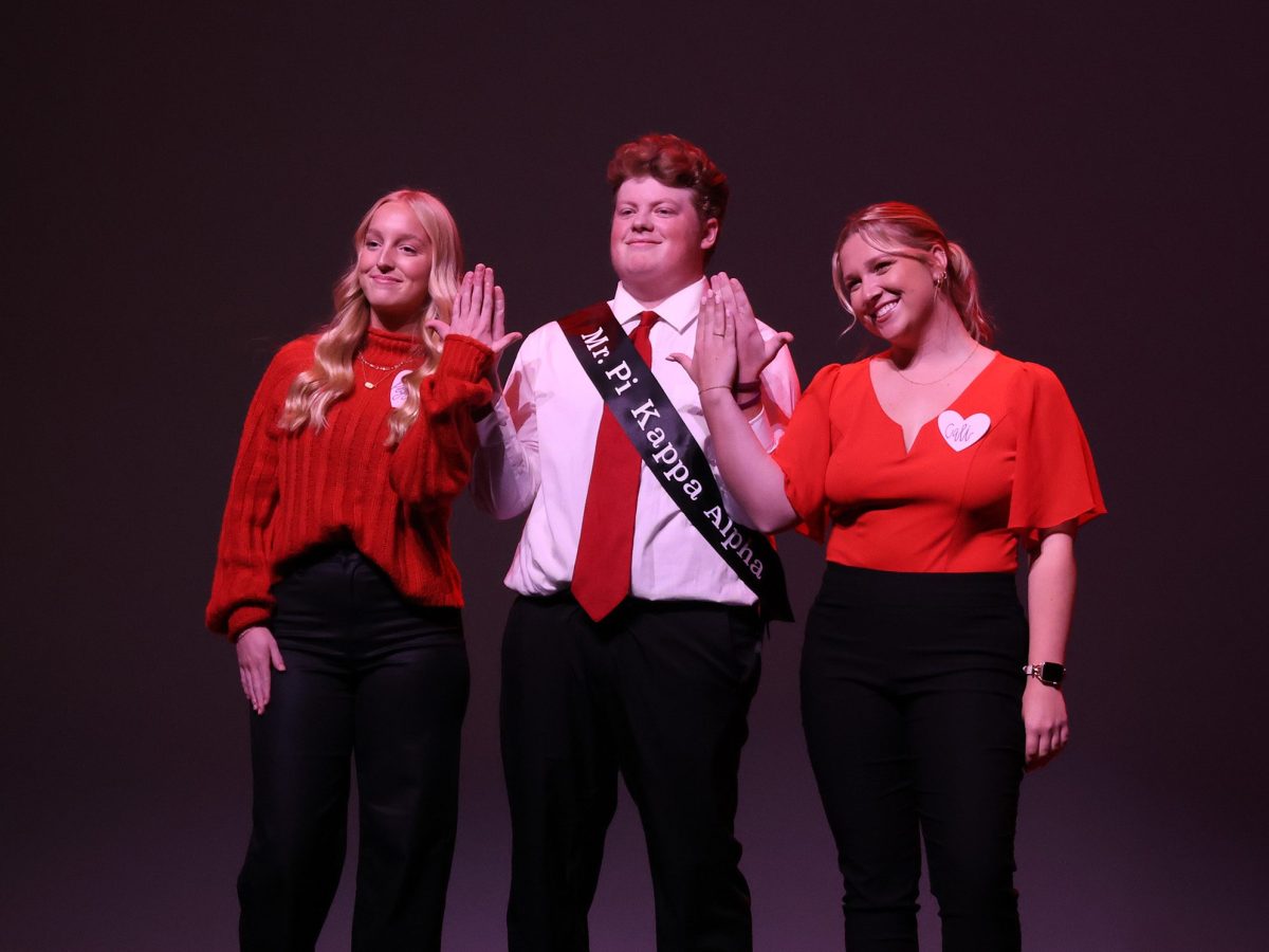 Mr. People's Choice, Jack Aschwege, raises the Alpha Phi hand symbol with coaches Peyton Henry and Cali Erickson. Photo by Jenna Heinz / Antelope Staff