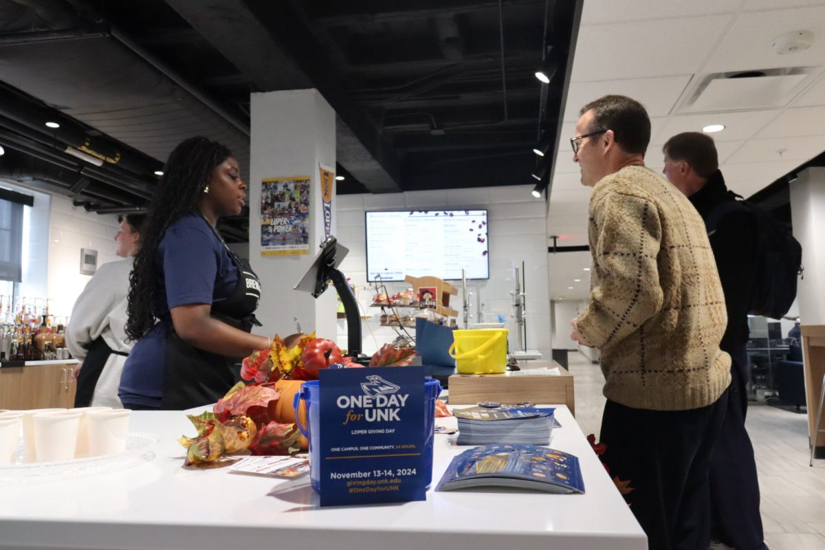 Godiva Kekeh serves Marc Bauer, UNK athletic director, during  Brewed Awakening's One Day for UNK celebration. Photo by Gabby Roche  / Antelope Staff