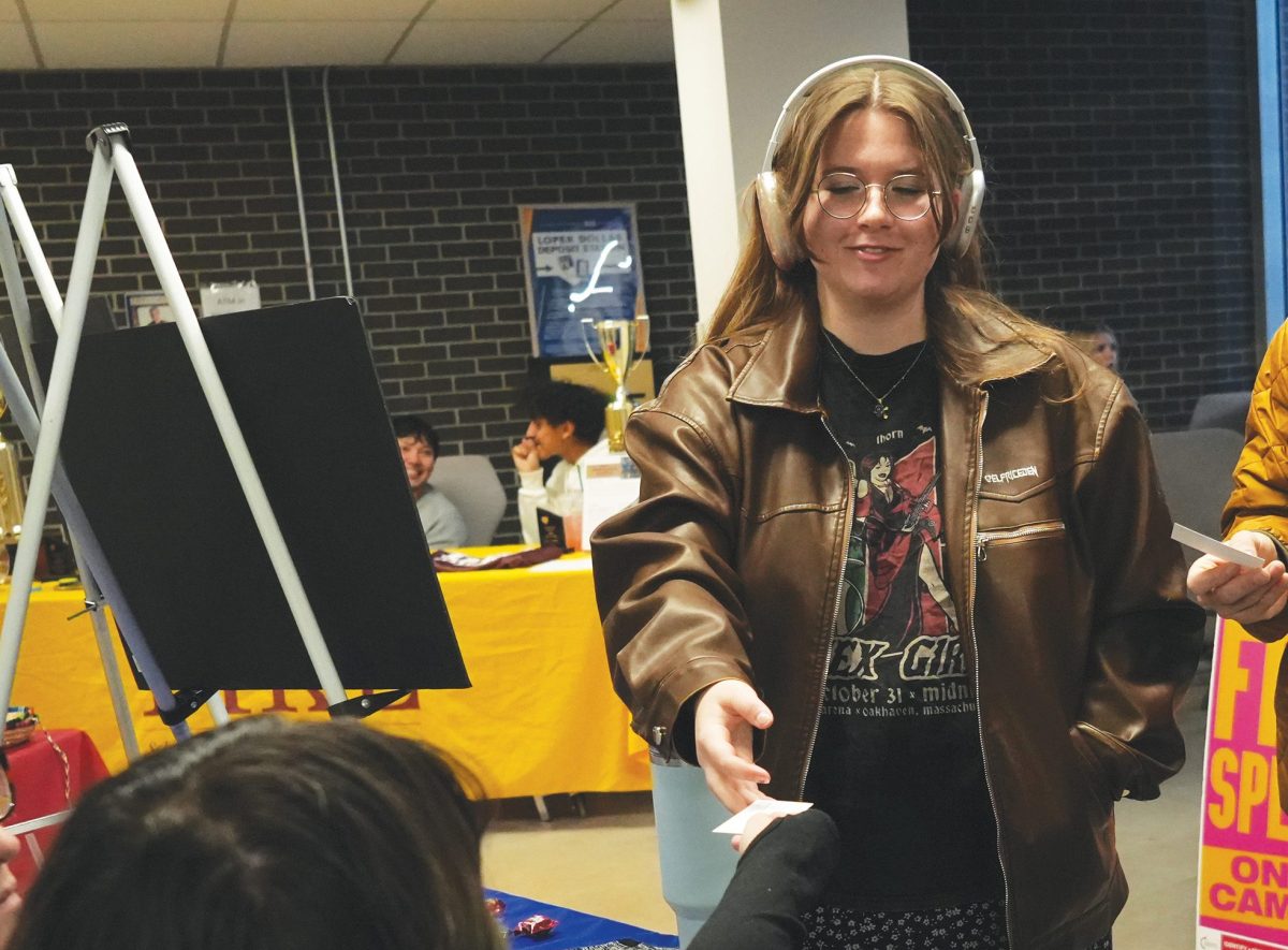 Jentry Pieper receives a Forensic Debate card from Charlie Blaes at the Student Organization Fair. Photo by Gabby Roche / Antelope Staff.