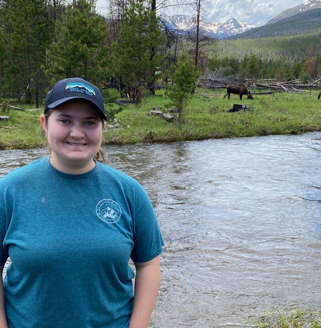 Kersie Delaney in Rocky Mountain National Park in Colorado pictured with a moose nearby. Photo by Kersie Delaney / Antelope Staff